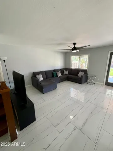 a living room with furniture and a air conditioner vent