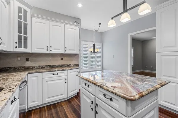 a kitchen with granite countertop wooden cabinets and white appliances