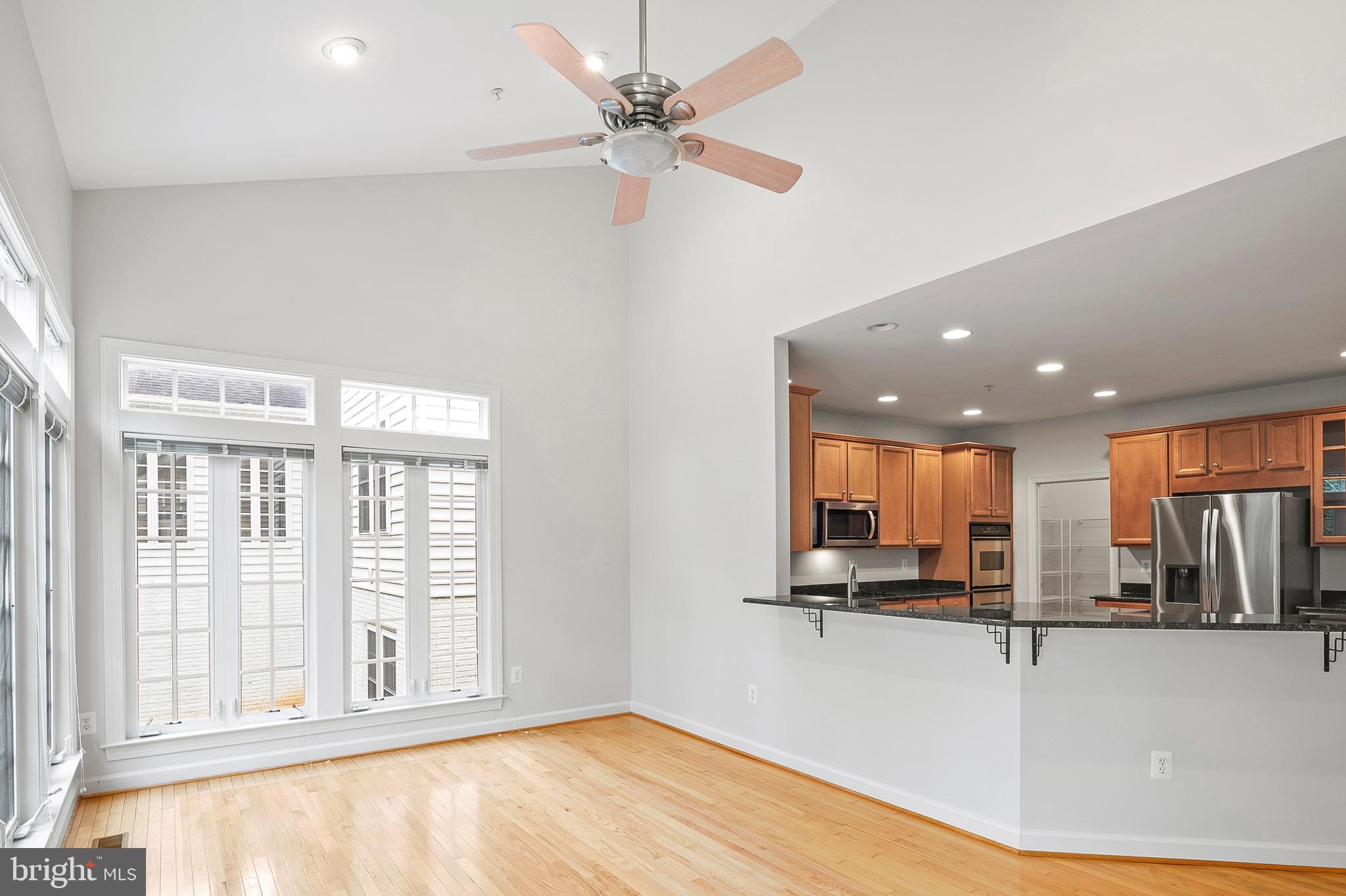 12912 Bay Hill Drive Beltsville, MD 20705 - Photo 20 of 60 a view of a kitchen with kitchen island stainless steel appliances wooden floor and a large window