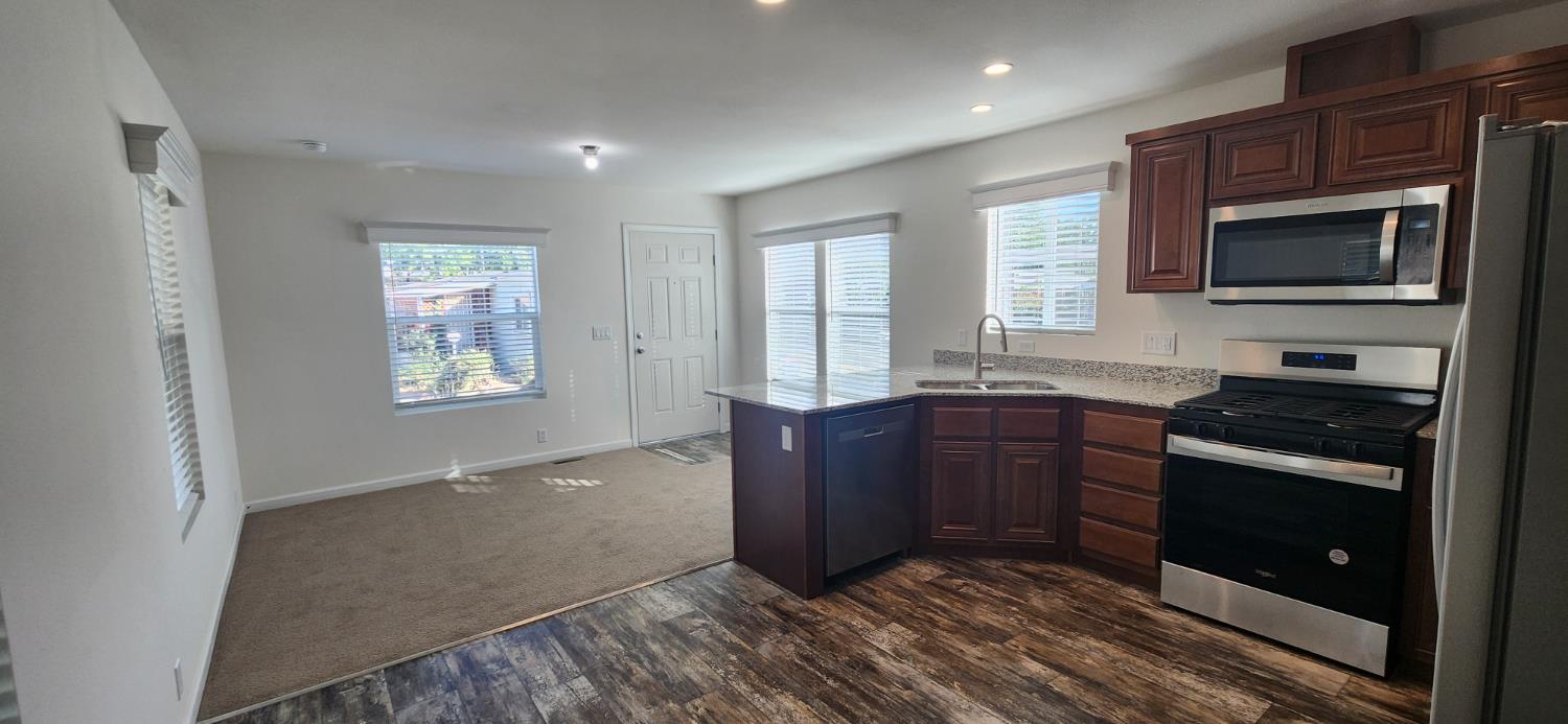 350 Pleasant Valley Road, Unit 56 Diamond Springs, CA 95619 - Photo 3 of 15 a kitchen with stainless steel appliances granite countertop a stove and a microwave