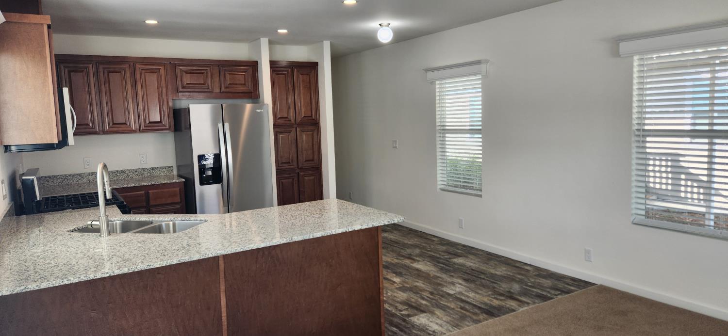 350 Pleasant Valley Road, Unit 56 Diamond Springs, CA 95619 - Photo 4 of 15 a kitchen with stainless steel appliances granite countertop a refrigerator and a sink