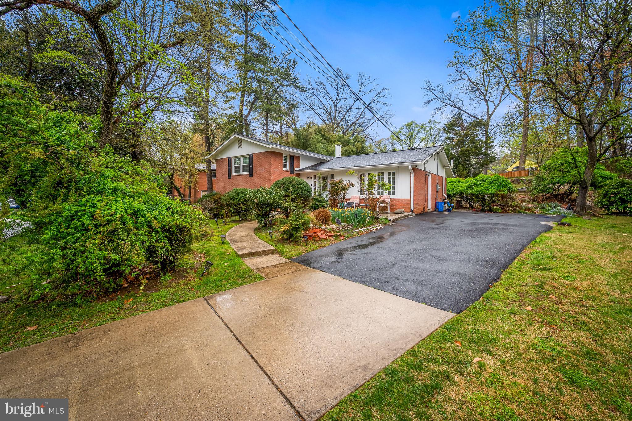 a front view of a house with a yard and trees
