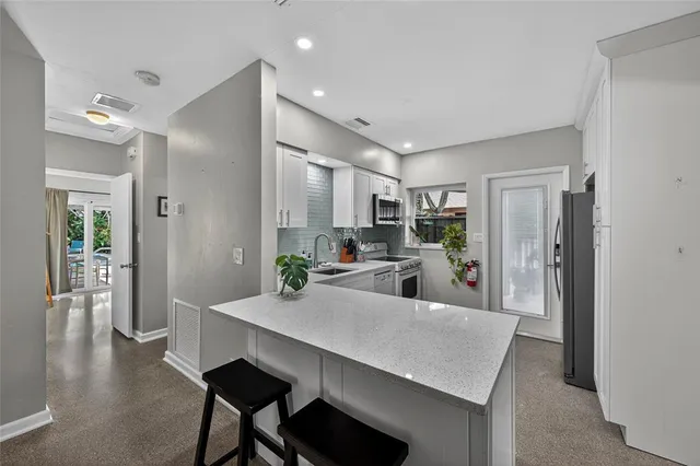 a view of a dining room and livingroom with furniture wooden floor a chandelier