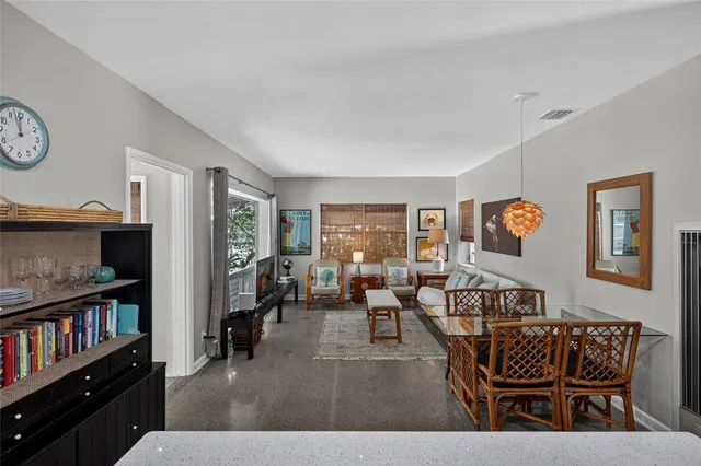 a living room with furniture and a bookshelf with wooden floor