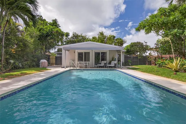 a view of a house with swimming pool and a yard