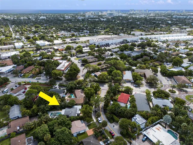 an aerial view of residential houses with outdoor space and ocean view