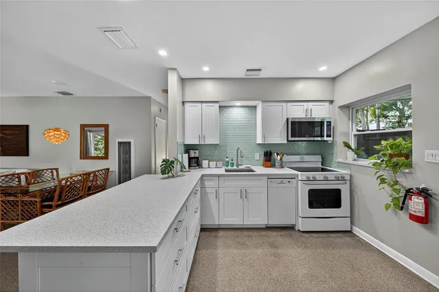 a kitchen with white cabinets and stainless steel appliances
