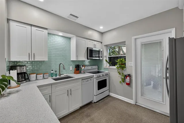 a kitchen with a sink a stove and cabinets