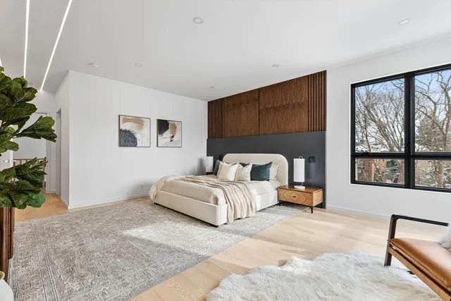 a spacious bedroom with a bed couch and a large window