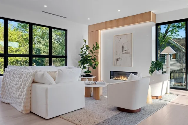 a living room with fireplace furniture and a large window