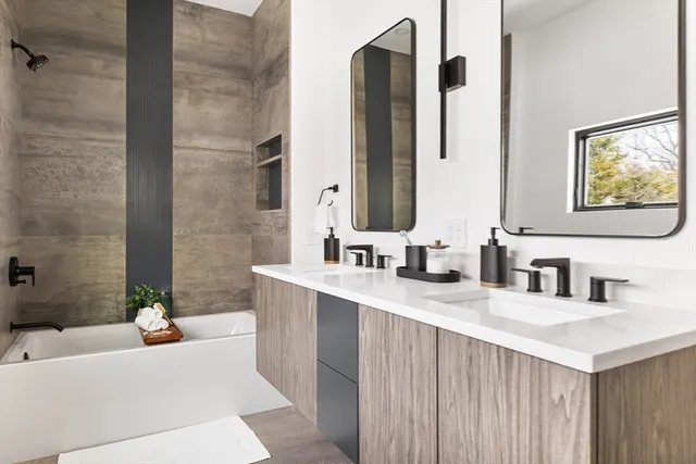 a bathroom with a double vanity sink mirror and bathtub