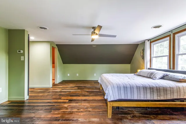 a bedroom with a bed and a painting on the wall
