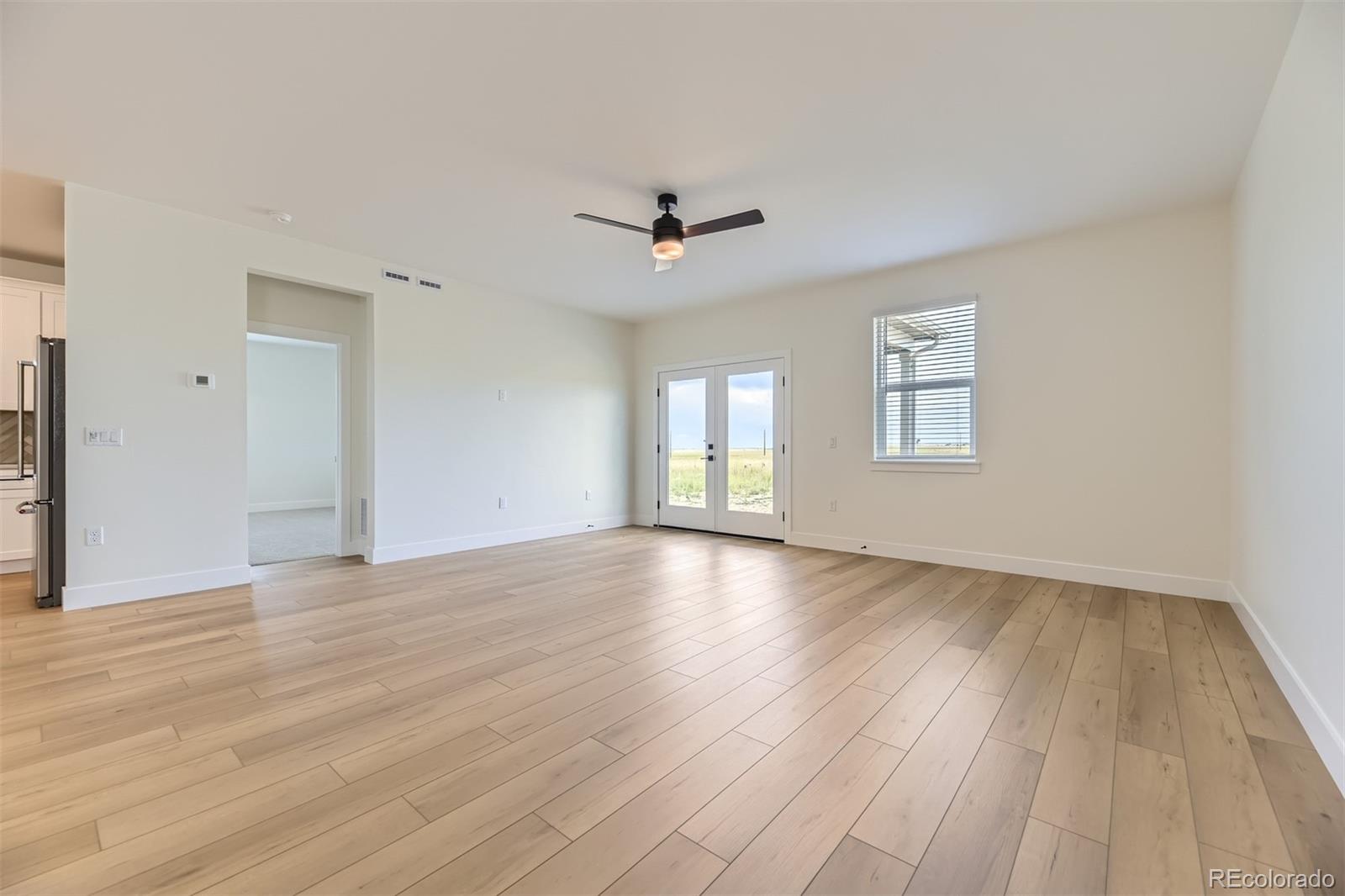 42974 Colonial Trail Elizabeth, CO 80107 - Photo 7 of 27 an empty room with wooden floor and windows