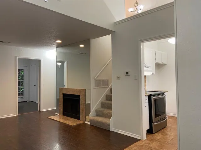 a view of a livingroom with wooden floor and a staircase