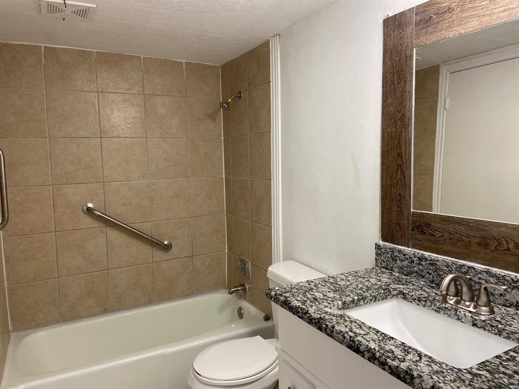 1440 Weiler Boulevard Fort Worth, TX 76112 - Photo 7 of 11 a bathroom with a granite countertop sink toilet mirror and bathtub