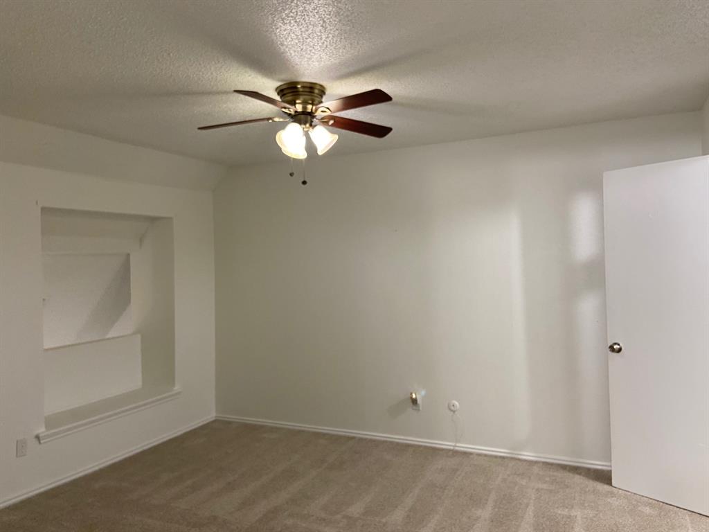 1440 Weiler Boulevard Fort Worth, TX 76112 - Photo 9 of 11 an empty room with a chandelier fan and windows