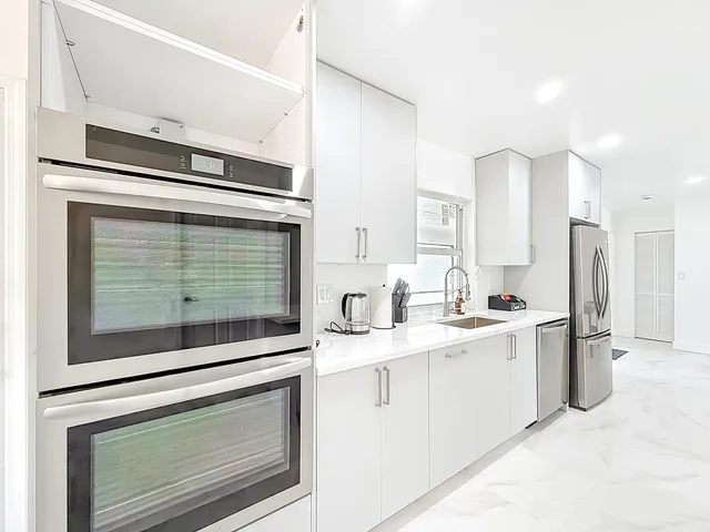 a kitchen with stainless steel appliances granite countertop a stove a sink and a microwave