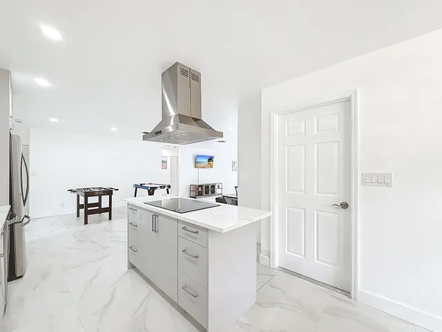 a kitchen with a sink a stove a refrigerator and white cabinets