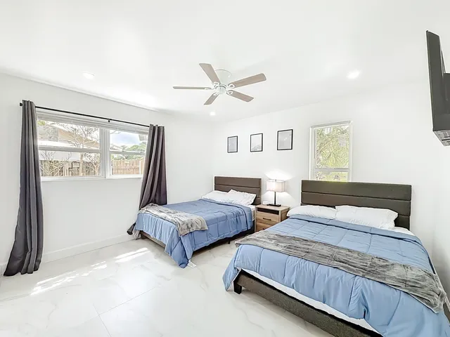 a bedroom with two beds and a window