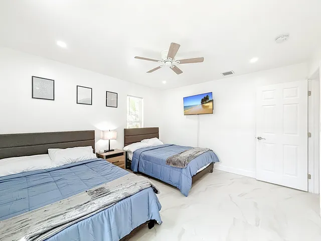 a bedroom with two separate beds and painting on the wall