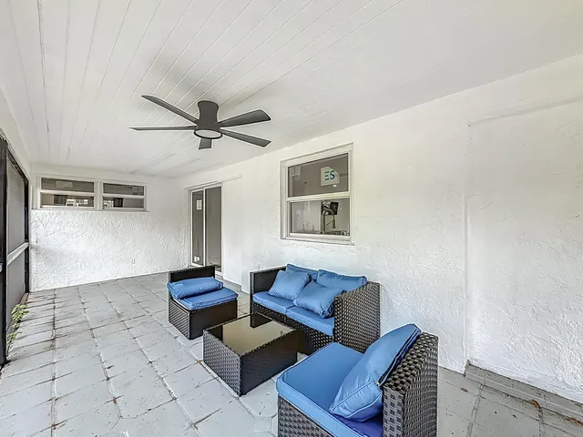 a living room with furniture and a floor to ceiling window