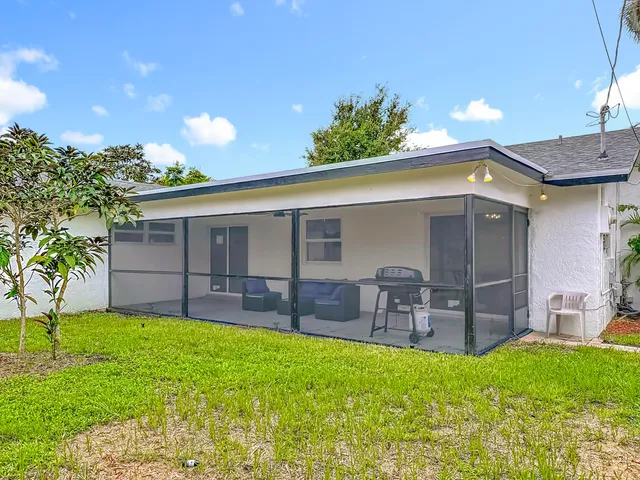 a view of a house with a big yard and potted plants