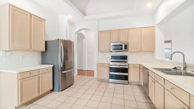 a kitchen with stainless steel appliances granite countertop a refrigerator sink and stove