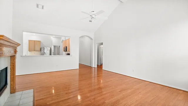 a view of a room with wooden floor and a ceiling fan