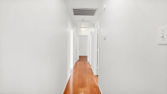 a view of a hallway with wooden floor