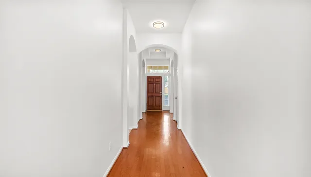 a view of a hallway with wooden floor