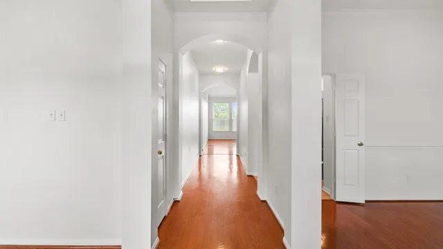 a view of a hallway with wooden floor and staircase