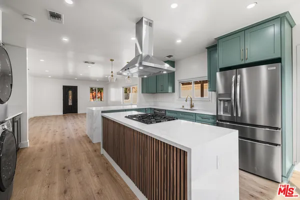 a kitchen with stainless steel appliances granite countertop a stove and a refrigerator