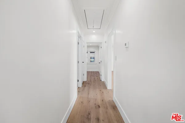 a view of a hallway with wooden floor and staircase