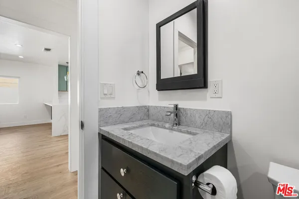 a bathroom with a granite countertop sink and a mirror