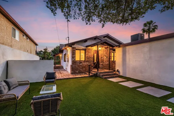 a backyard of a house with table and chairs