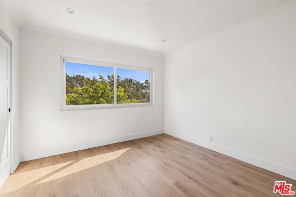 a view of a room with wooden floor and window
