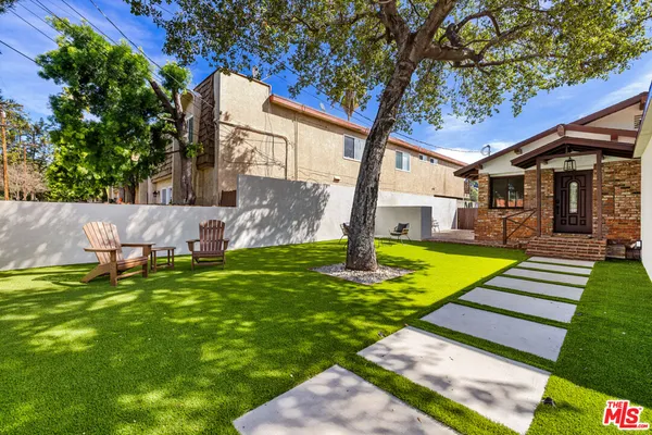 a view of a house with backyard and a tree