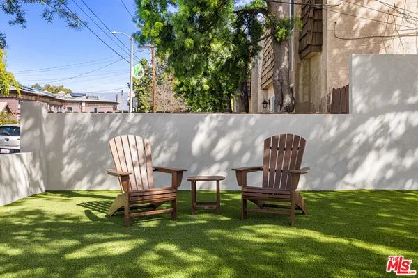 a swimming pool with outdoor seating and wooden bench