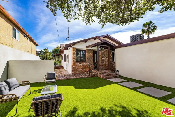 a backyard of a house with table and chairs