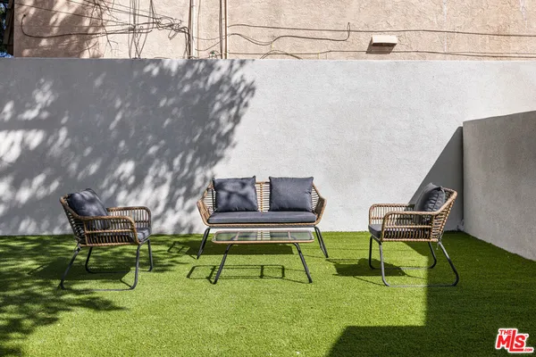 a view of a backyard with wooden floor and potted plants