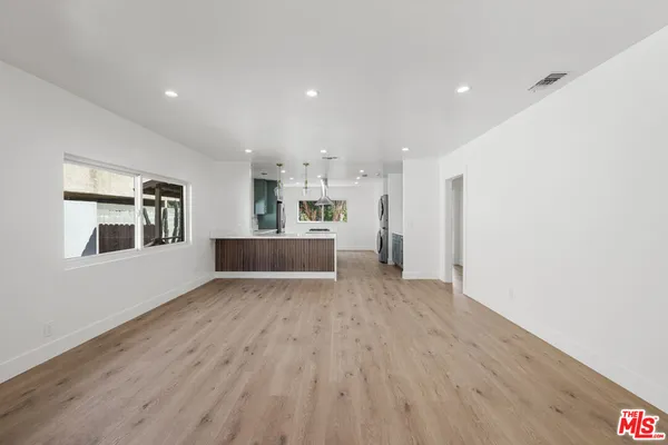 a view of a kitchen with wooden floor and windows