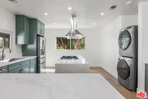 a kitchen with kitchen island granite countertop a stove and a sink