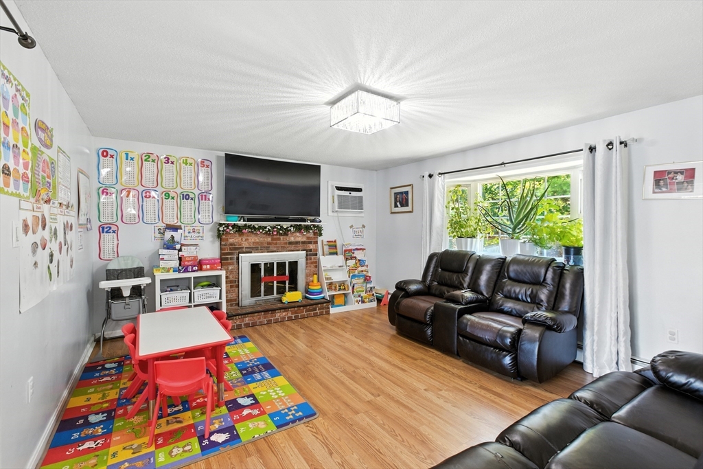169 Berkeley Street Methuen, MA 01844 - Photo 3 of 31 a living room with furniture a flat screen tv and a fireplace