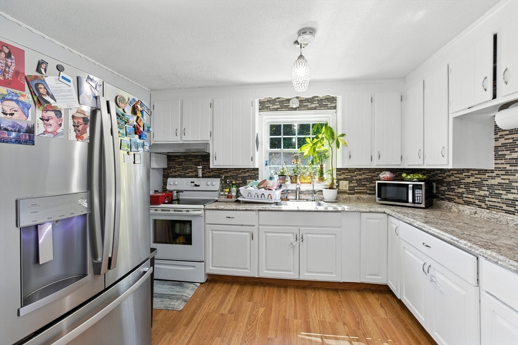 169 Berkeley Street Methuen, MA 01844 - Photo 8 of 31 a kitchen with stainless steel appliances a stove a sink and a refrigerator