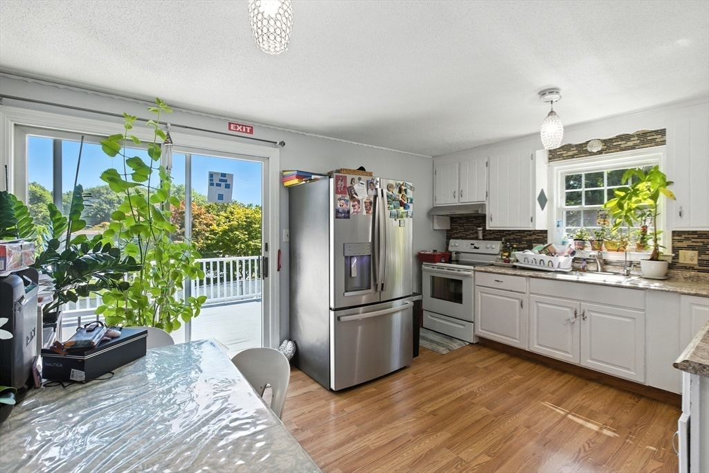 169 Berkeley Street Methuen, MA 01844 - Photo 9 of 31 a kitchen with granite countertop a refrigerator a oven a counter space and a window