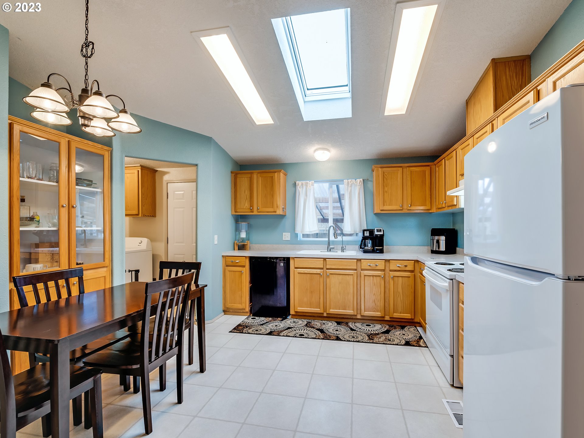 29720 Jeans Road, Unit 22 Veneta, OR 97487 - Photo 13 of 30 a kitchen with a refrigerator a stove top oven a sink dishwasher and a dining table with wooden floor