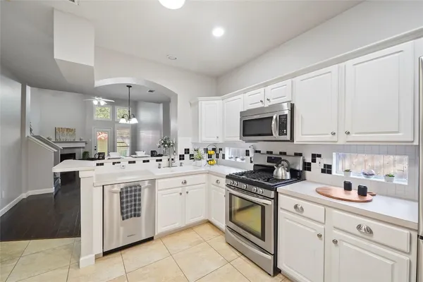 a kitchen with stainless steel appliances granite countertop a stove a sink and a microwave