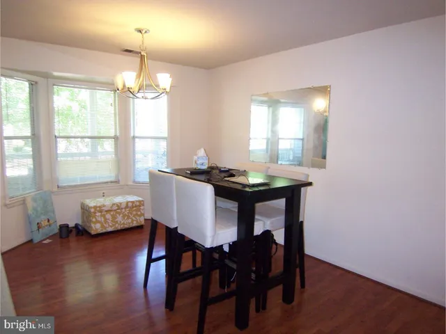 a dining room with furniture a chandelier and wooden floor
