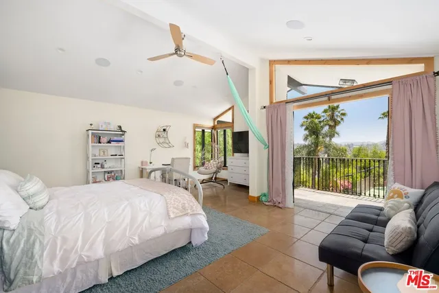 a spacious bedroom with a bed couch and a large window