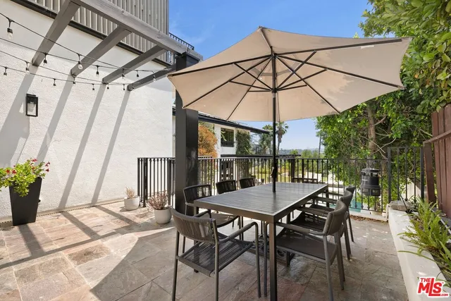 a view of patio with a table and chairs under an umbrella
